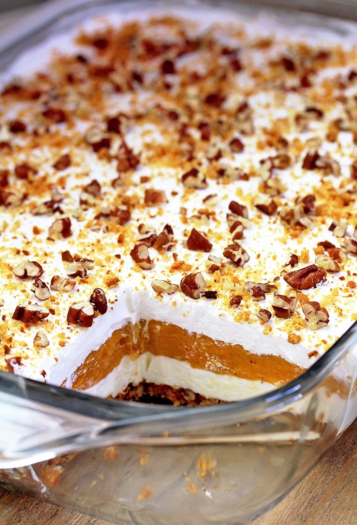 Pumpkin Lush – ce dessert crémeux rapide, léger mais délicieux, avec de la crème au fromage et des couches de citrouille, et une croûte de biscuits au gingembre, garnie de pacanes hachées et de miettes de biscuits au gingembre, ravira tous les amateurs de citrouille.