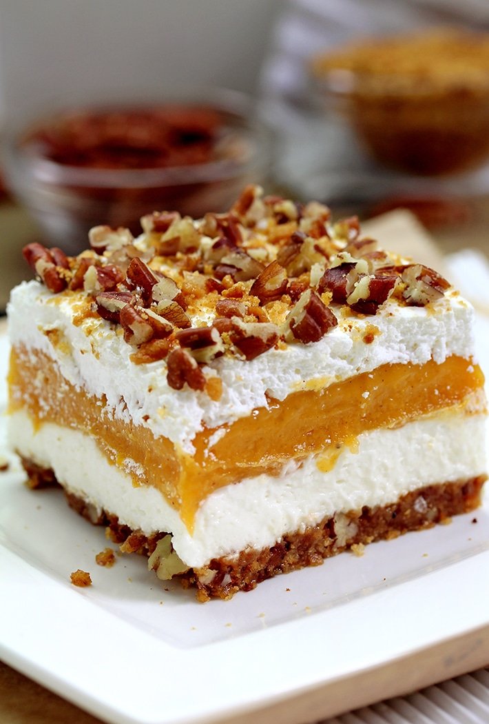 Pumpkin Lush – ce dessert crémeux rapide, léger mais délicieux, avec de la crème au fromage et des couches de citrouille, et une croûte de biscuits au gingembre, garnie de pacanes hachées et de miettes de biscuits au gingembre, ravira tous les amateurs de citrouille