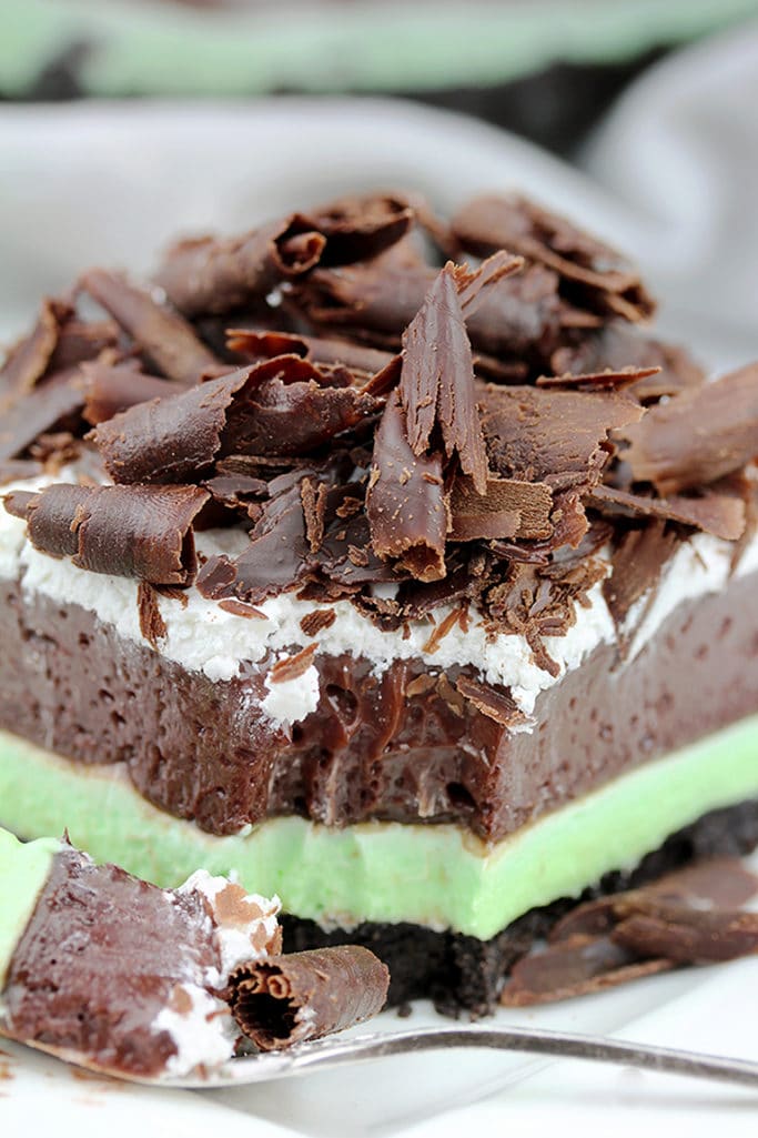 Mint Chocolate Lasagna easy no-bake dessert with layers of Oreo crust, Mint cream cheese, Chocolate pudding, Whipping Cream and Chocolate Curls on top.