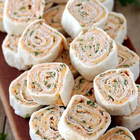 Taco Tortilla Roll Ups this quick and easy party appetizer filled with cream cheese, sour cream, chicken, cheddar cheese, taco seasoning, taco sauce and parsley is perfect for every holiday or a party.