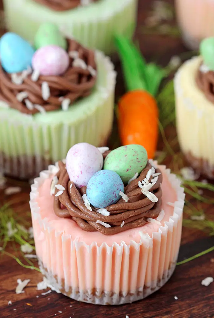 Easter Mini Cheesecakes – are so perfectly creamy that they melt in your mouth. Graham cracker crust, cream cheese filling, chocolate buttercream nest and Easter egg candies make this incredible mini Easter dessert.