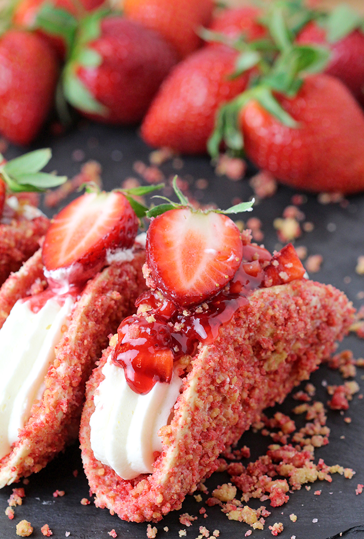 Strawberry Crunch Cheesecake Tacos – crunchy tortilla shell coated in white chocolate and strawberry crunch, creamy cheesecake filling, topped with fresh strawberries and strawberry syrup is a true delight!